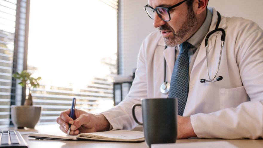 Doctor at clinic writing in his diary